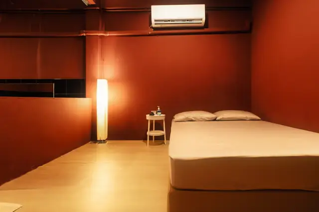 Photo: the venue's own website SENTO Bangkok: red-walled room with a bed and floor lamp